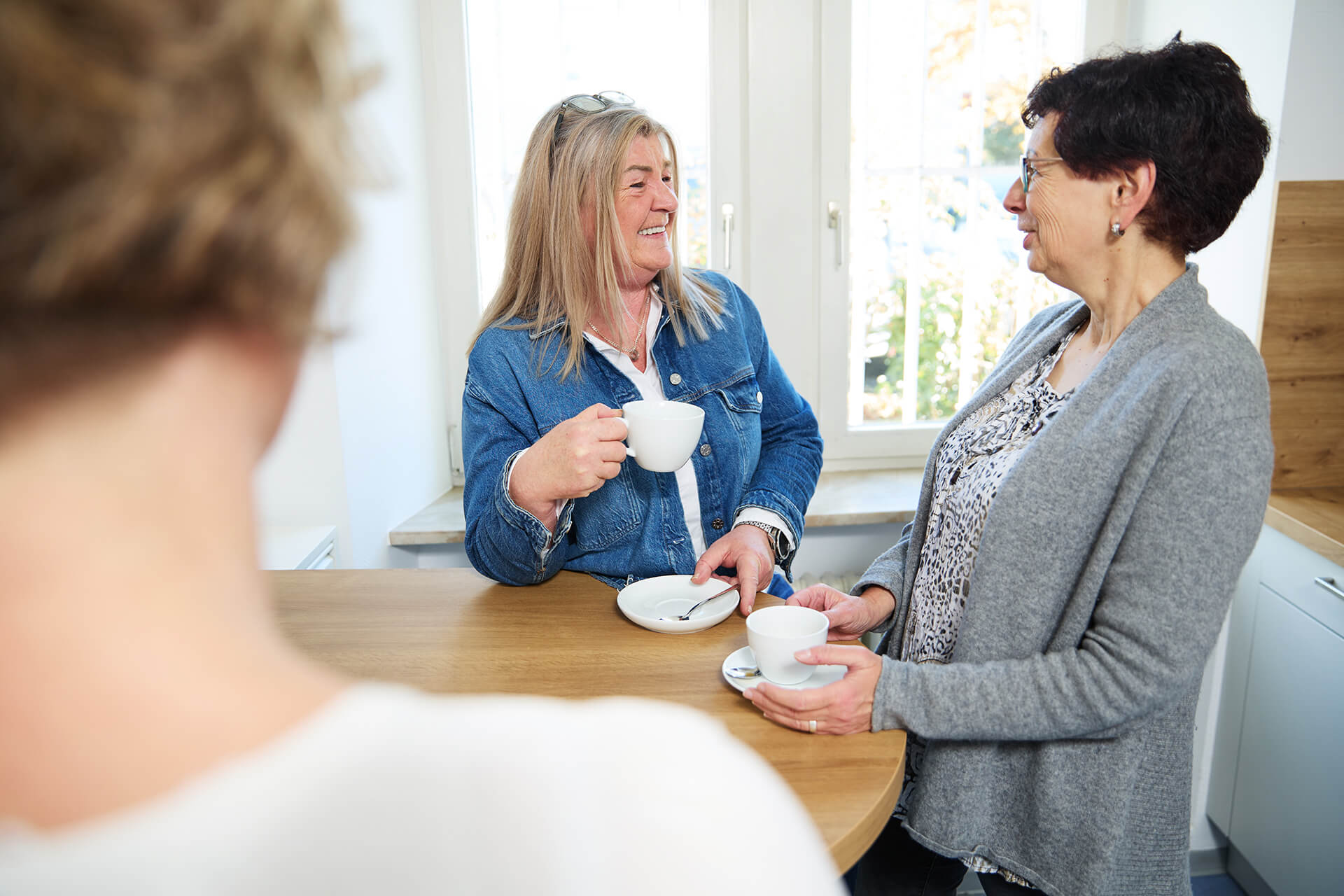 Kolleginnen im entspannten Austausch in der Teeküche einer modernen Steuerkanzlei
